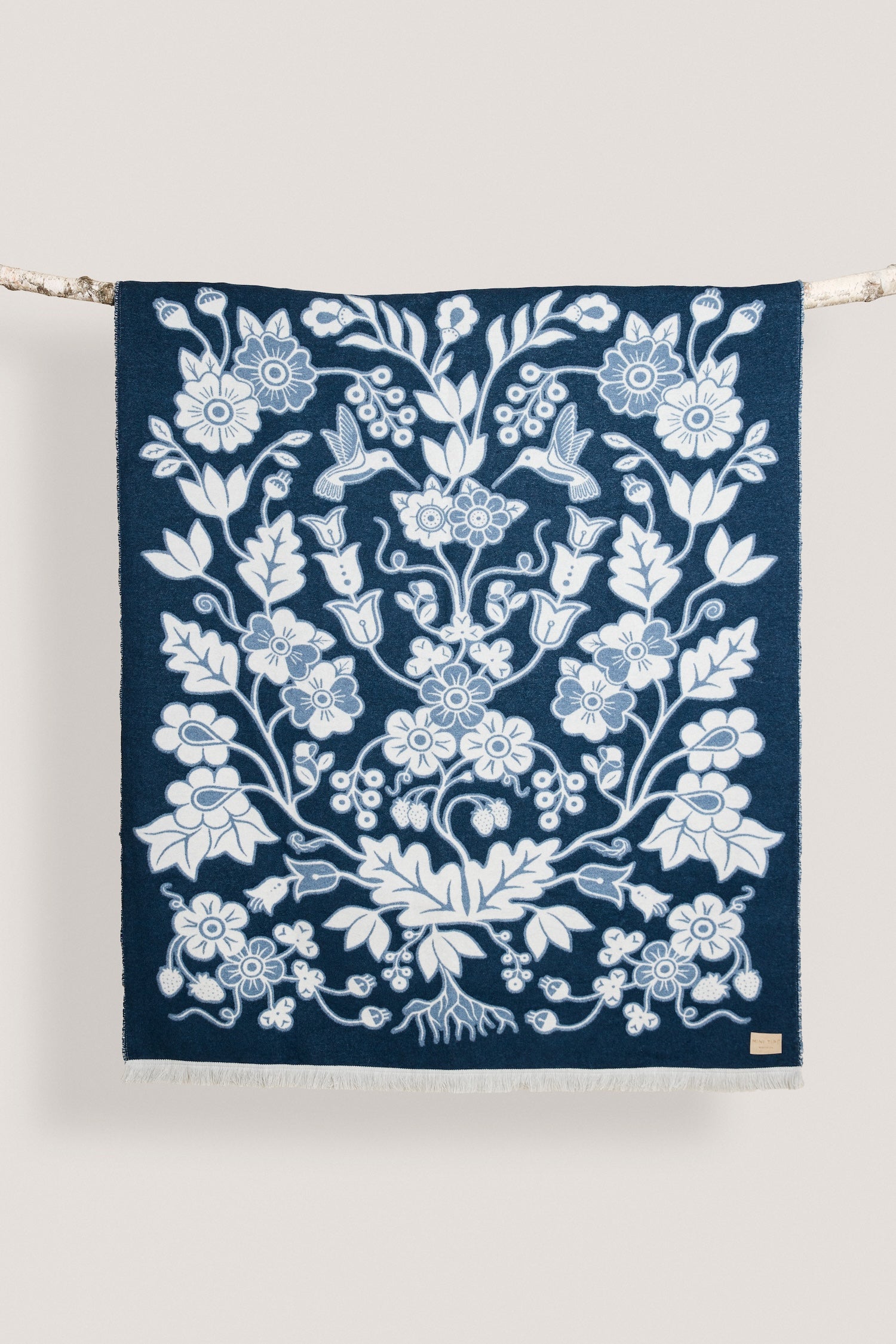 Navy blue wool blanket with a white floral pattern on a white background
