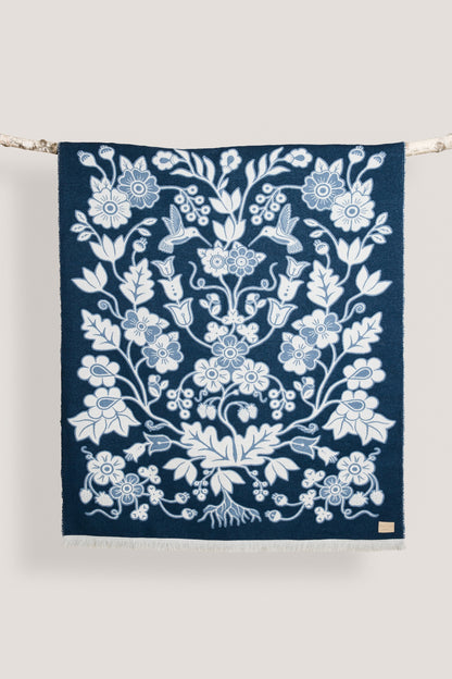 Navy blue wool blanket with a white floral pattern on a white background